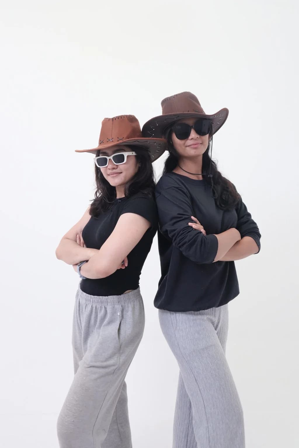 Foto couple berpose saling membelakangi dengan topi koboi